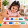 Preschool child learning basic shapes with colourful wooden geometric blocks and shape cards